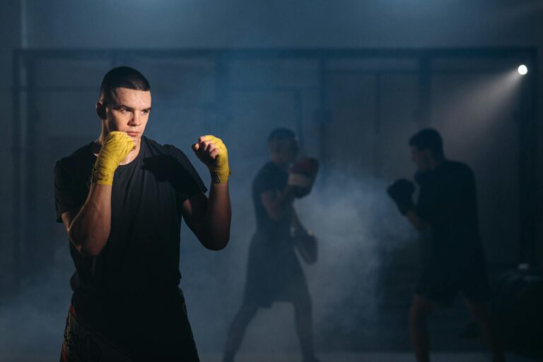 MMA fighter practices techniques with intensity in a smoky gym environment, showcasing focus and dedication.