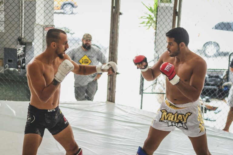 Two men practicing mixed martial arts in a gym, showcasing combat skills.